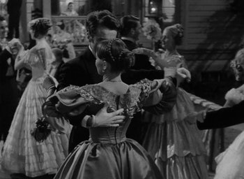 Movie still from “The Heiress” (1949), directed by William Wyler – A black and white photo of people dancing; Medium shot, Over the shoulder angle