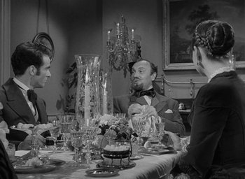 Movie still from “The Heiress” (1949), directed by William Wyler – A group of people sitting around a dinner table; Medium shot, Over the shoulder angle
