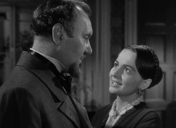 Movie still from “The Heiress” (1949), directed by William Wyler – An old photo of a man and a woman looking at each other; Close Up shot, Over the shoulder angle