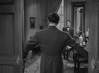 Movie still from “The Heiress” (1949), directed by William Wyler – A man standing in front of a mirror in front of another man; Medium shot, Over the shoulder angle