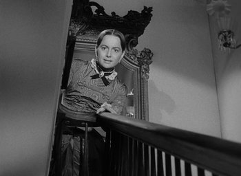 Movie still from “The Heiress” (1949), directed by William Wyler – A woman standing on the stairs of a house; Medium shot, Low angle