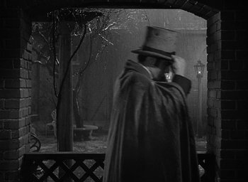 Movie still from “The Heiress” (1949), directed by William Wyler – A man wearing a top hat and a long coat; Medium shot, Over the shoulder angle