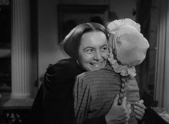 Movie still from “The Heiress” (1949), directed by William Wyler – A woman hugging a child in a room with a window; Medium shot, Over the shoulder angle