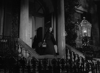 Movie still from “The Heiress” (1949), directed by William Wyler – A black and white photo of a woman walking down the stairs; Wide shot, Low angle