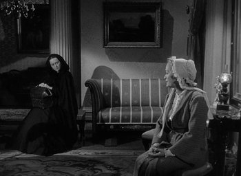 Movie still from “The Heiress” (1949), directed by William Wyler – Two women sitting in a living room , one of whom is wearing a black robe; Wide shot, Over the shoulder angle