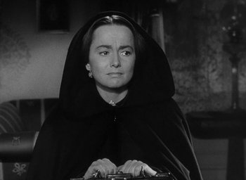Movie still from “The Heiress” (1949), directed by William Wyler – A black and white photo of a woman in a hooded cloak; Close Up shot, High angle