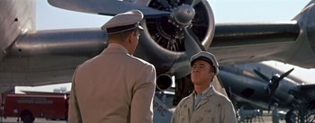 Movie still from “The High and the Mighty” (1954), directed by William A. Wellman – Two men in uniform standing in front of an airplane; Medium shot, Low angle