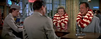 Movie still from “The High and the Mighty” (1954), directed by William A. Wellman – A man and a woman sitting at a table; Medium shot, Over the shoulder angle