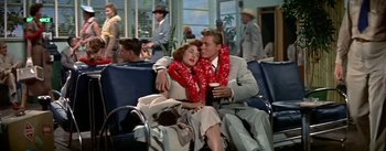 Movie still from “The High and the Mighty” (1954), directed by William A. Wellman – A man and a woman sitting next to each other on a bench; Wide shot, High angle