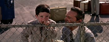 Movie still from “The High and the Mighty” (1954), directed by William A. Wellman – A man and a boy standing next to each other; Medium shot, Over the shoulder angle