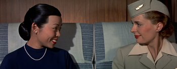 Movie still from “The High and the Mighty” (1954), directed by William A. Wellman – A man and a woman sitting next to each other on a bench; Close Up shot, High angle