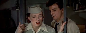 Movie still from “The High and the Mighty” (1954), directed by William A. Wellman – A man and a woman wearing military uniforms; Close Up shot, Low angle
