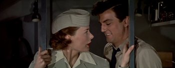 Movie still from “The High and the Mighty” (1954), directed by William A. Wellman – A man and a woman are smiling at each other; Close Up shot, Low angle