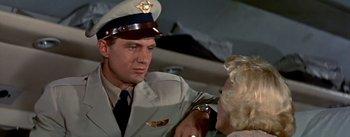 Movie still from “The High and the Mighty” (1954), directed by William A. Wellman – A man in a military uniform and a woman in a white dress; Close Up shot, Low angle