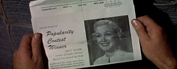 Movie still from “The High and the Mighty” (1954), directed by William A. Wellman – An old newspaper with a picture of a woman in it; Extreme Close Up shot, Overhead angle