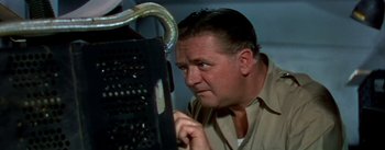 Movie still from “The High and the Mighty” (1954), directed by William A. Wellman – A man is looking at a computer screen; Close Up shot, Low angle