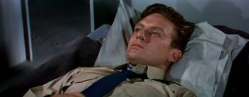 Movie still from “The High and the Mighty” (1954), directed by William A. Wellman – A person laying on a couch; Close Up shot, High angle