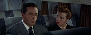Movie still from “The High and the Mighty” (1954), directed by William A. Wellman – A man and a woman sitting next to each other on a plane; Close Up shot, High angle