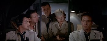 Movie still from “The High and the Mighty” (1954), directed by William A. Wellman – A man and a woman in uniform on a train; Medium shot, Low angle