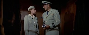 Movie still from “The High and the Mighty” (1954), directed by William A. Wellman – A man and a woman dressed in military uniforms; Medium shot, Low angle