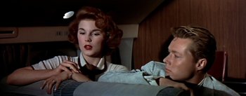 Movie still from “The High and the Mighty” (1954), directed by William A. Wellman – A woman sitting next to another woman in a car; Close Up shot, Overhead angle