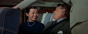 Movie still from “The High and the Mighty” (1954), directed by William A. Wellman – An older man and a young woman smiling for the camera; Medium shot, Over the shoulder angle