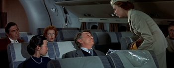 Movie still from “The High and the Mighty” (1954), directed by William A. Wellman – A man and two women sitting on a plane; Medium shot, Over the shoulder angle