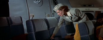 Movie still from “The High and the Mighty” (1954), directed by William A. Wellman – An airline stewardess looking over the back of an airplane; Medium shot, Overhead angle