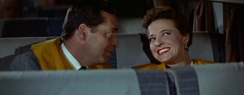 Movie still from “The High and the Mighty” (1954), directed by William A. Wellman – A man and a woman sitting next to each other on a train; Close Up shot, Low angle