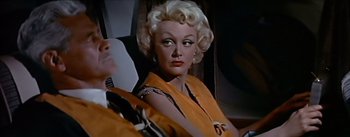 Movie still from “The High and the Mighty” (1954), directed by William A. Wellman – An older woman with blonde curly hair sitting in a chair; Close Up shot, Low angle