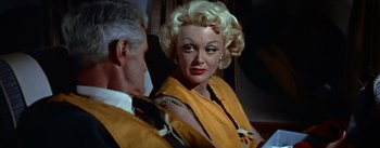 Movie still from “The High and the Mighty” (1954), directed by William A. Wellman – An older man and woman looking in the same mirror; Close Up shot, Over the shoulder angle