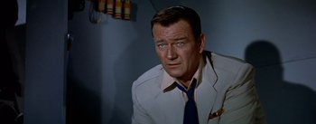 Movie still from “The High and the Mighty” (1954), directed by William A. Wellman – A person wearing a suit and tie; Close Up shot, Over the shoulder angle