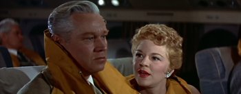 Movie still from “The High and the Mighty” (1954), directed by William A. Wellman – An older man sitting next to an older woman; Close Up shot, Low angle