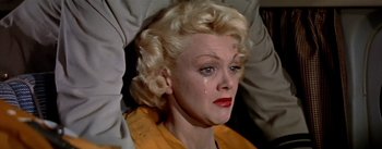 Movie still from “The High and the Mighty” (1954), directed by William A. Wellman – A woman with blonde curly hair crying; Close Up shot, High angle
