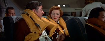 Movie still from “The High and the Mighty” (1954), directed by William A. Wellman – A man and a woman wearing life jackets on a boat; Medium shot, Low angle