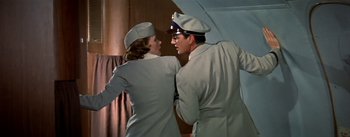 Movie still from “The High and the Mighty” (1954), directed by William A. Wellman – A man and a woman in uniform are standing together; Medium shot, Low angle
