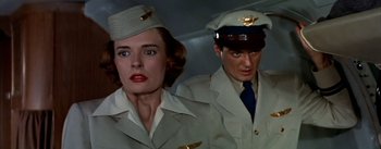 Movie still from “The High and the Mighty” (1954), directed by William A. Wellman – A man and a woman in uniform standing next to each other; Close Up shot, Low angle