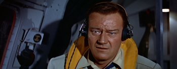 Movie still from “The High and the Mighty” (1954), directed by William A. Wellman – An older man wearing headphones and a white shirt; Close Up shot, Low angle