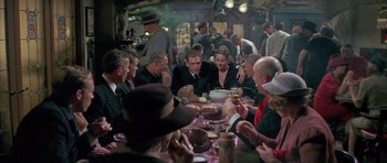 Movie still from “The Hindenburg” (1975), directed by Robert Wise – A group of people sitting around a table eating food; Wide shot, Over the shoulder angle