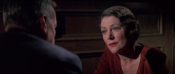 Movie still from “The Hindenburg” (1975), directed by Robert Wise – An older woman sitting in front of a younger man; Close Up shot, Over the shoulder angle