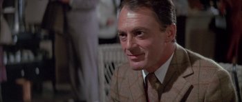 Movie still from “The Hindenburg” (1975), directed by Robert Wise – A person wearing a suit and tie; Close Up shot, Over the shoulder angle