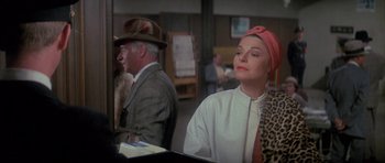 Movie still from “The Hindenburg” (1975), directed by Robert Wise – An older woman wearing a hat and a white jacket; Medium shot, Over the shoulder angle