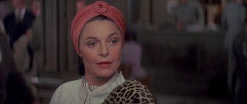 Movie still from “The Hindenburg” (1975), directed by Robert Wise – An older woman wearing a head scarf and a necklace; Close Up shot, Over the shoulder angle