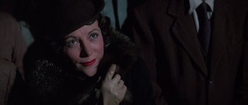 Movie still from “The Hindenburg” (1975), directed by Robert Wise – A person wearing a coat and hat; Close Up shot, Low angle