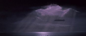 Movie still from “The Hindenburg” (1975), directed by Robert Wise – A purple sky with dark clouds over a body of water; Extreme Wide shot, Low angle