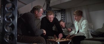 Movie still from “The Hindenburg” (1975), directed by Robert Wise – A group of men playing a game of chess; Medium shot, High angle