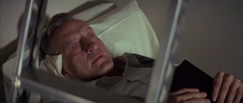 Movie still from “The Hindenburg” (1975), directed by Robert Wise – A person laying in a bed; Close Up shot, High angle