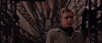 Movie still from “The Hindenburg” (1975), directed by Robert Wise – A man standing in front of an iron staircase; Medium shot, Low angle