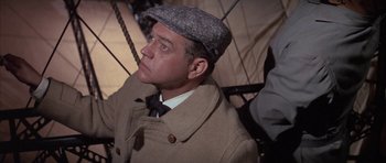 Movie still from “The Hindenburg” (1975), directed by Robert Wise – A man wearing a hat and a coat; Close Up shot, Low angle