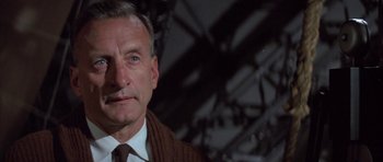 Movie still from “The Hindenburg” (1975), directed by Robert Wise – An older man wearing a sweater and a tie; Close Up shot, Low angle